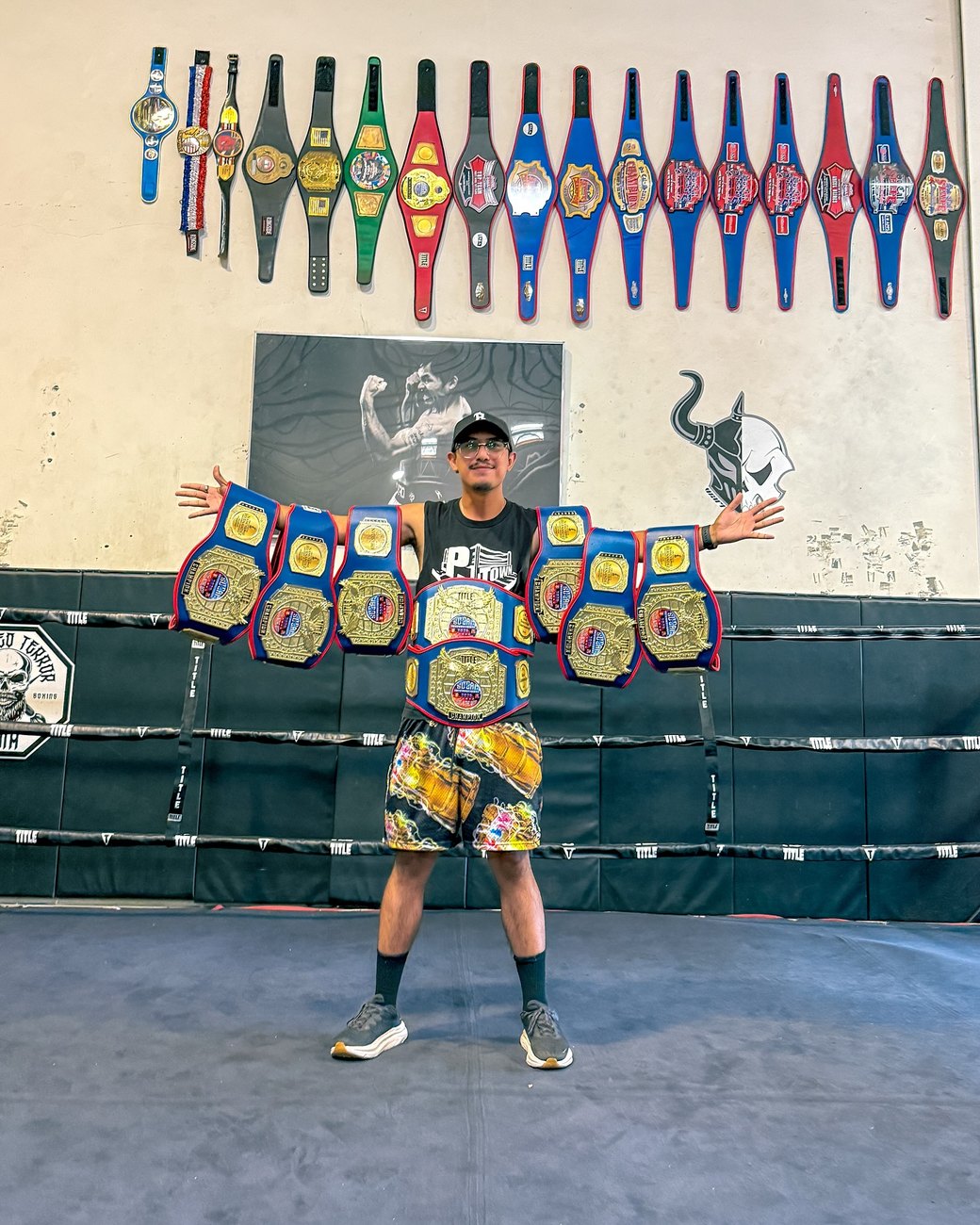 Coach with a stack of championship belts